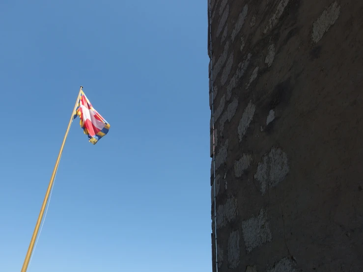 a flag flying from a pole next to a tall building