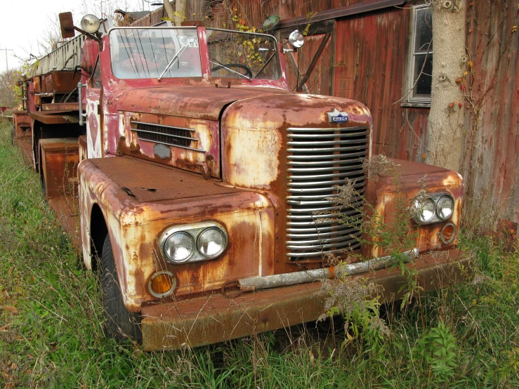 an old truck parked next to a wooden building