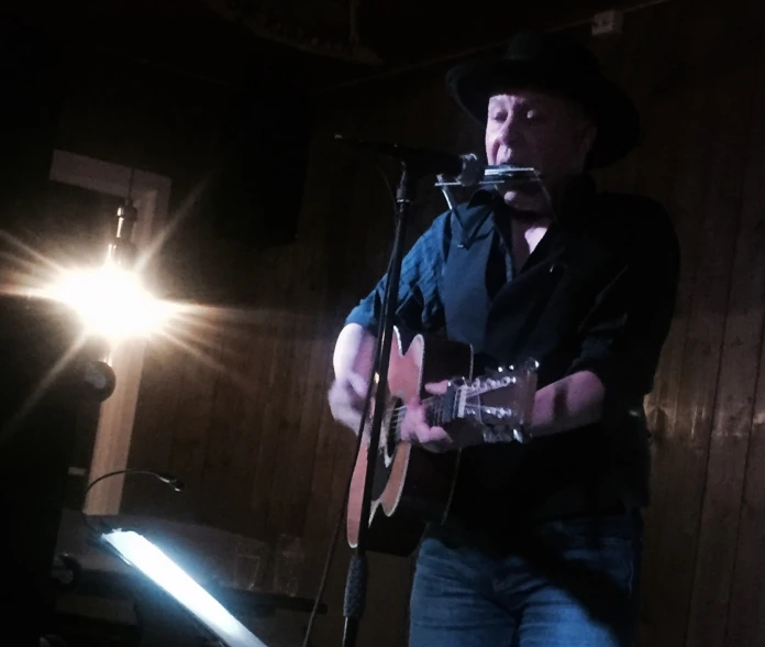 a man singing into a microphone while holding a guitar