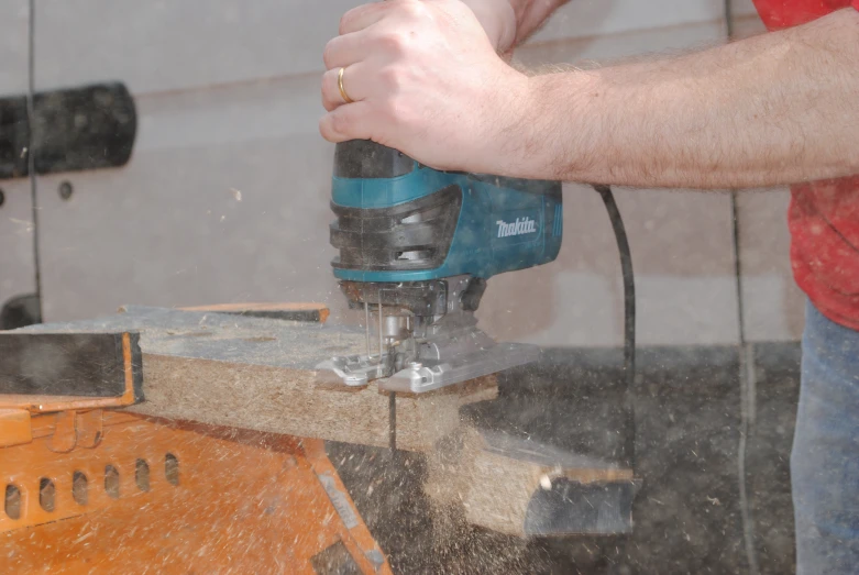 a person uses a power tool on some wood