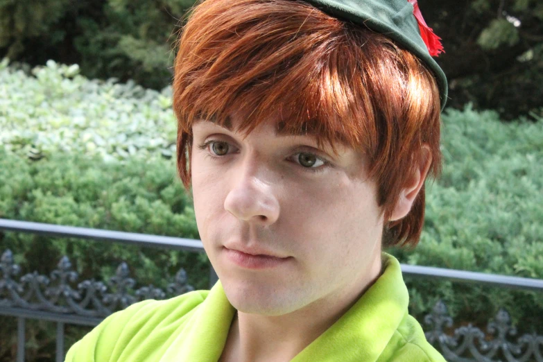 a young man wearing a green shirt and hat