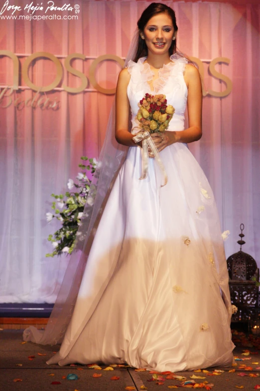 a woman in wedding dress posing with bouquet