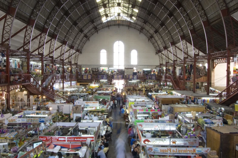 a building full of tables and stalls with people walking around