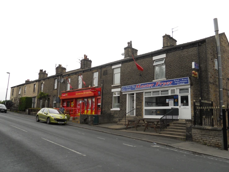 a red double decker bus parked outside of a brick building