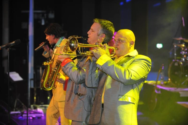 two men with yellow jackets playing on instruments