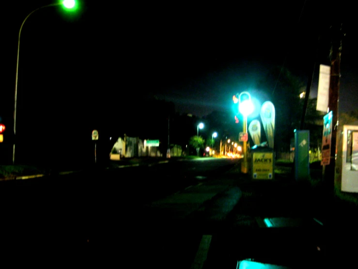 a dark street that is lit up with green light