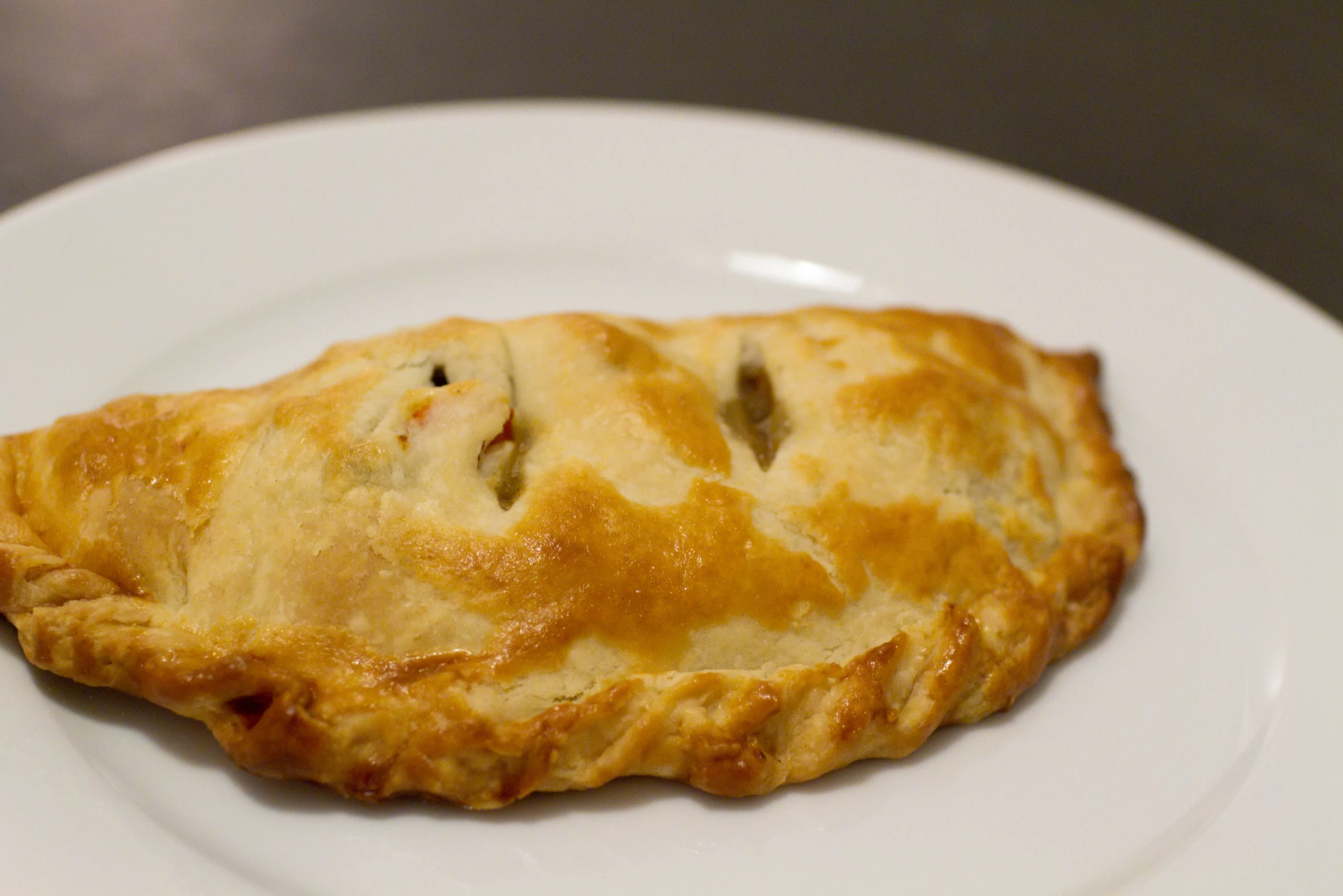 the pastry is topped with meat on a white plate