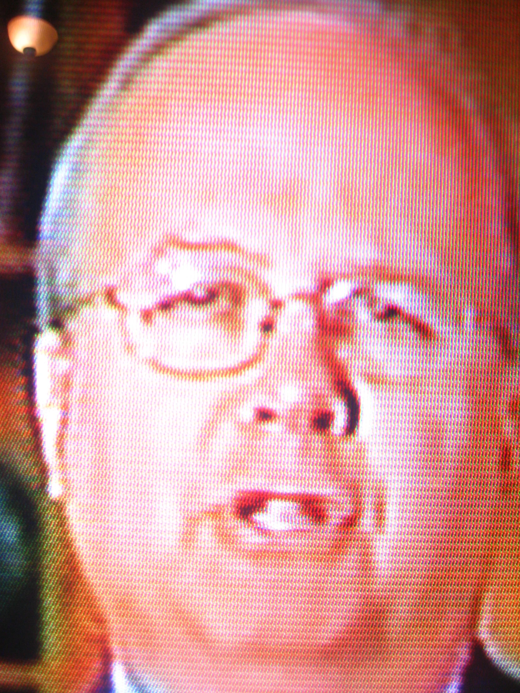 a man in glasses and a tie with a video message