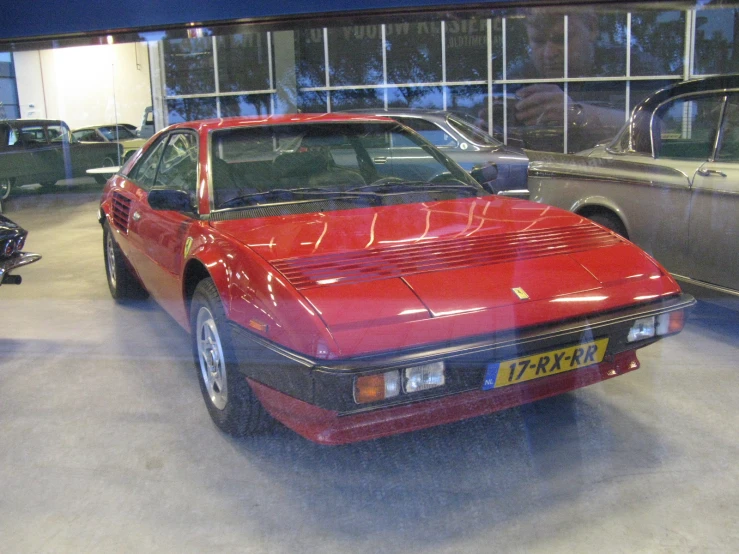 a red sports car sitting inside of a garage