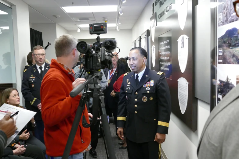 a military officer being interviewed in front of media