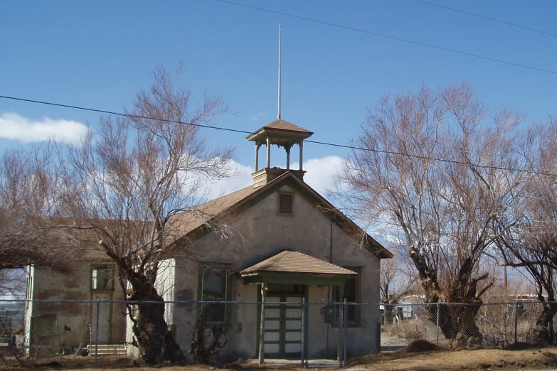 an old abandoned house with a tall steeple on top of it