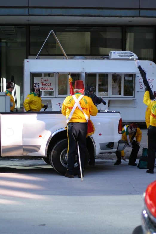 a man dressed in yellow paints the windows on a truck