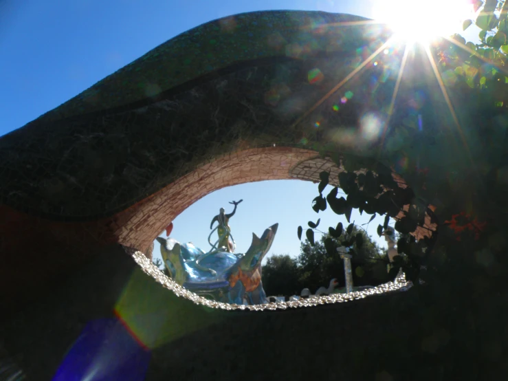 a view looking through a mirror to a statue of a woman with a spear