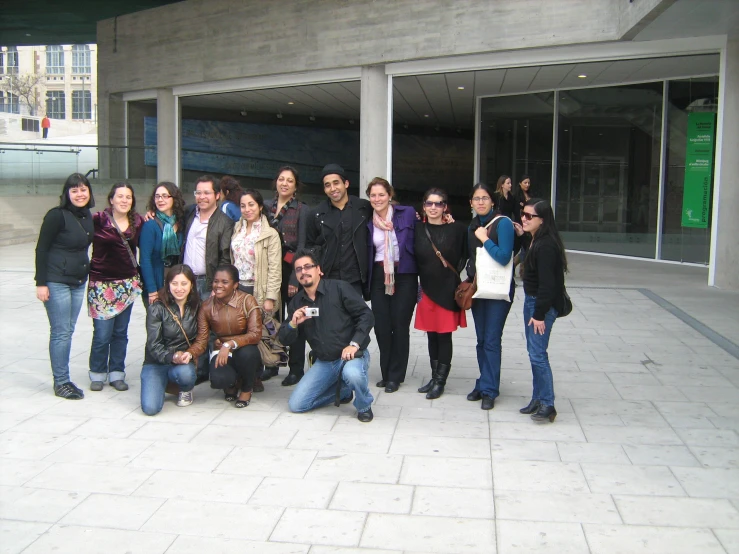 many people are standing on the street posing for a picture