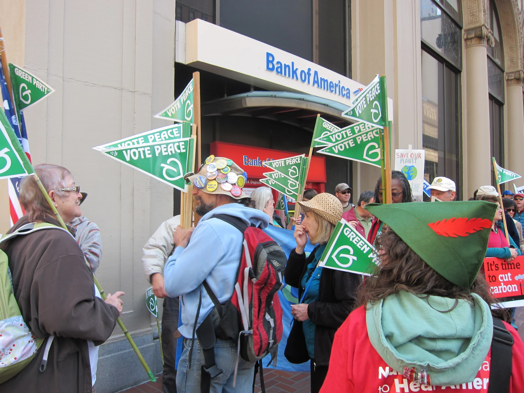 people standing on the sidewalk with many signs