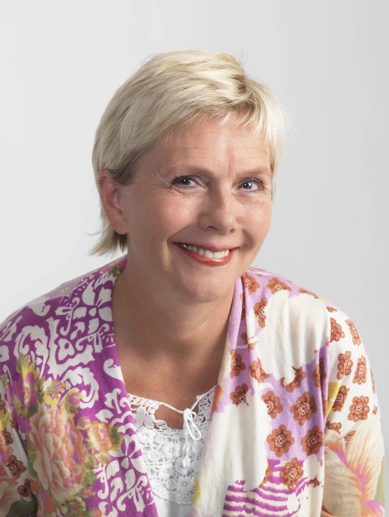 a woman smiles with her hair up into the air