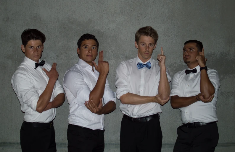 three men in bow ties posing together with one another