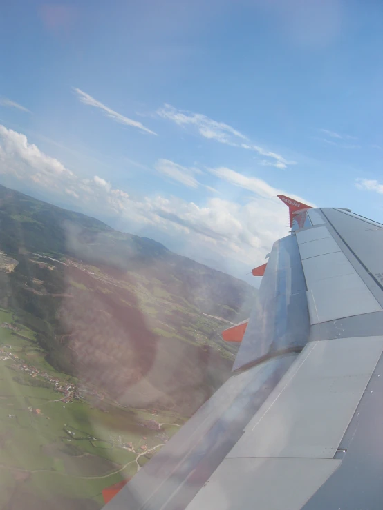 a plane is flying over a green valley