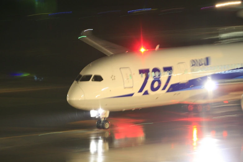 an airplane sitting on top of a runway at night