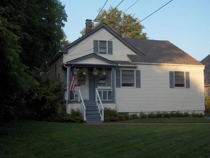 a small white house with grass in front of it