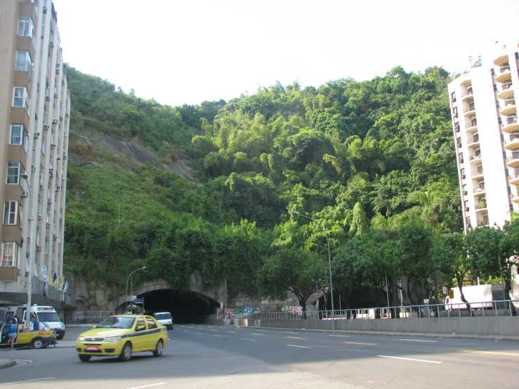 two cars driving down a road with a tunnel between them