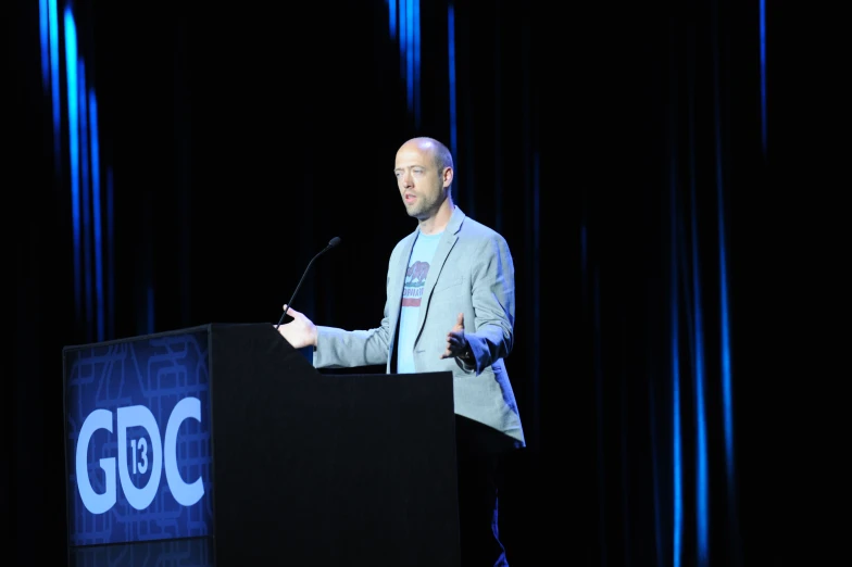 a man in a business suit is giving a speech