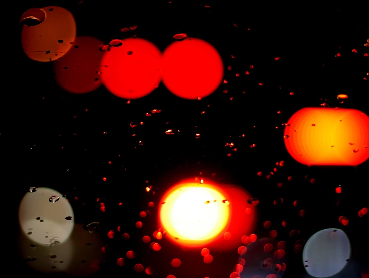 an orange light surrounded by other traffic lights at night