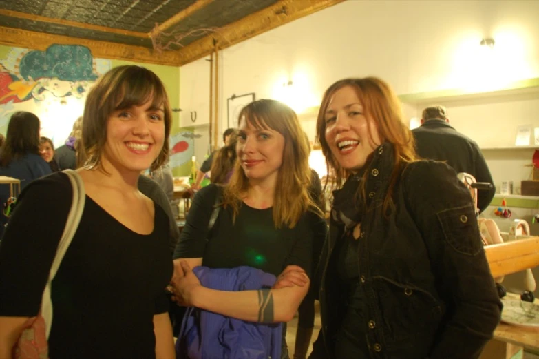 three women standing next to each other near a counter