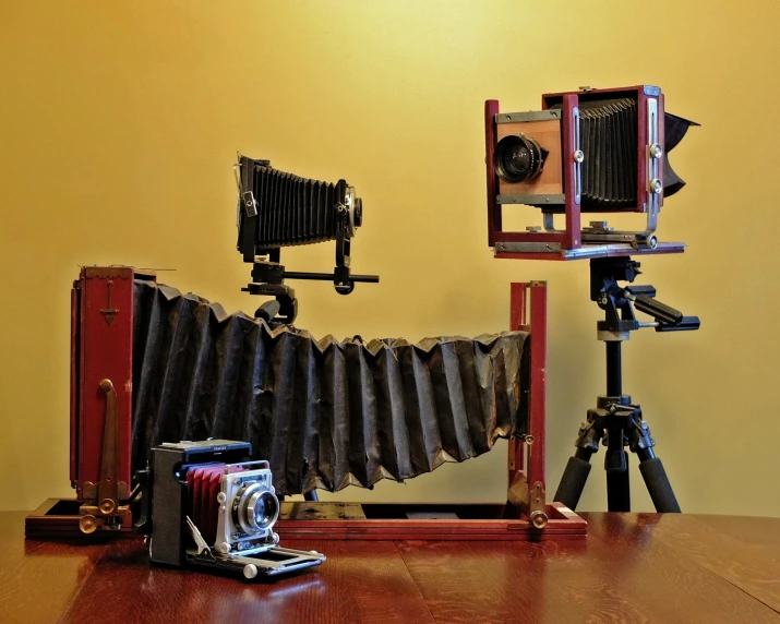 old cameras next to a large pair of tripod cameras