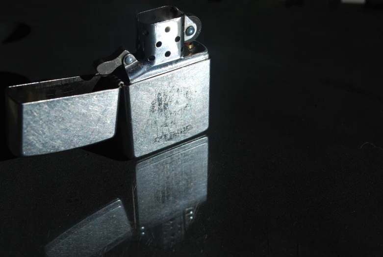 a close up of a silver lighter on the ground