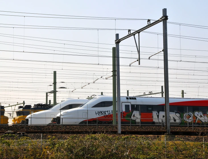 a couple of white and red trains on a track