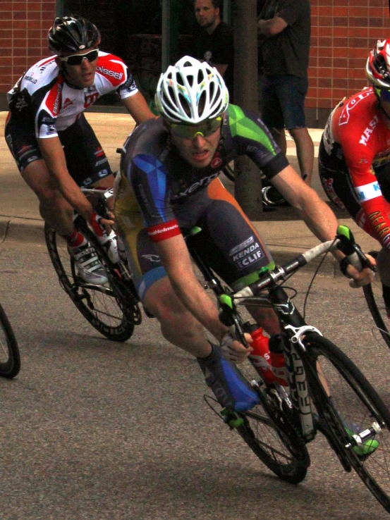 three men are riding their bikes in a bike race