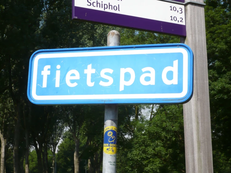 a couple of purple and white street signs on a pole