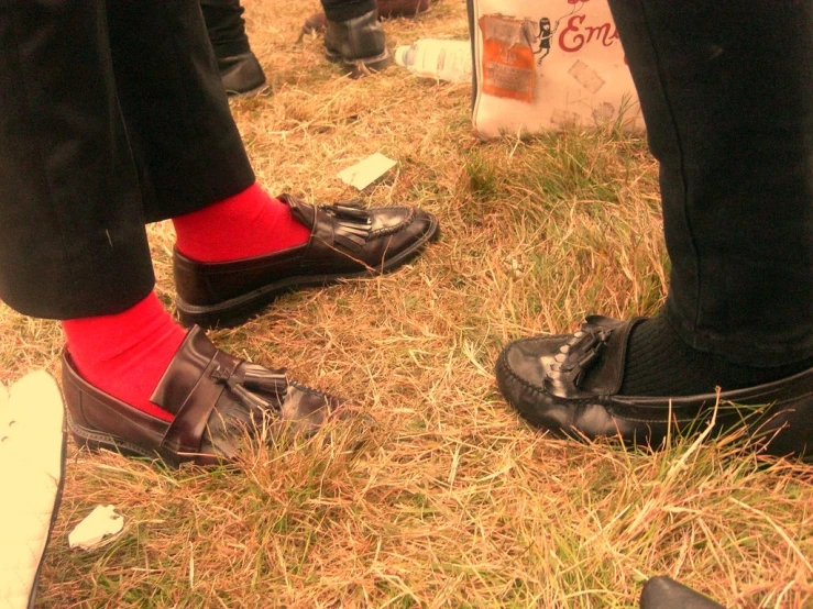 the foot of a man wearing black shoes and red socks