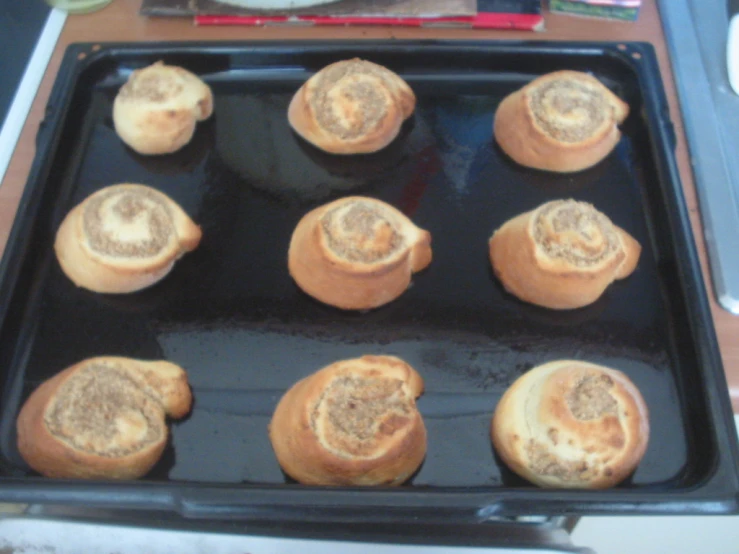 a pan full of cinnamon rolls sitting on top of a stove