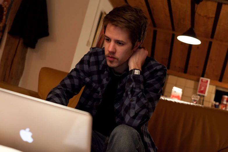 a man sitting at a table next to a laptop computer