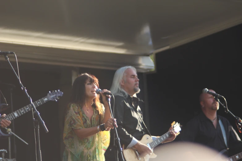 a group of people on stage with a microphone and music equipment