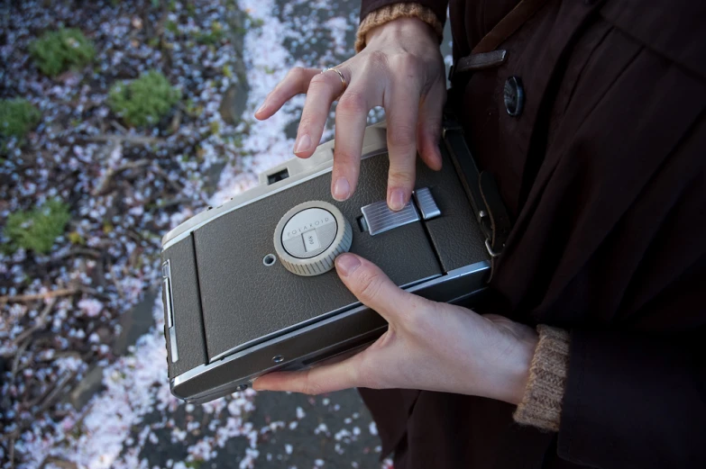 a woman holding an old electronic device in her hands