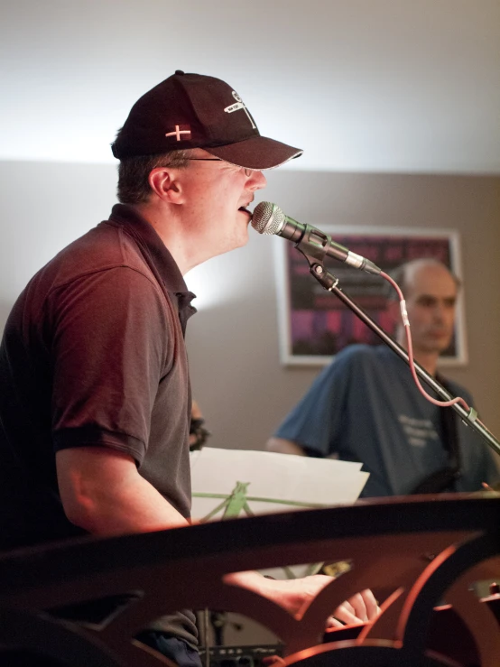 a man playing guitar while wearing a hat