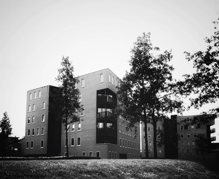 two large buildings on a street next to some trees