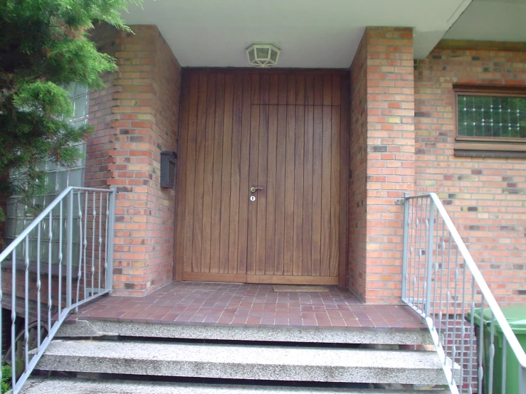 a staircase leading to a wooden door with glass 