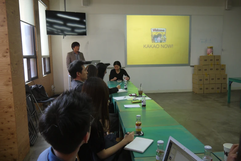 a group of people sitting at a table while people hold a seminar