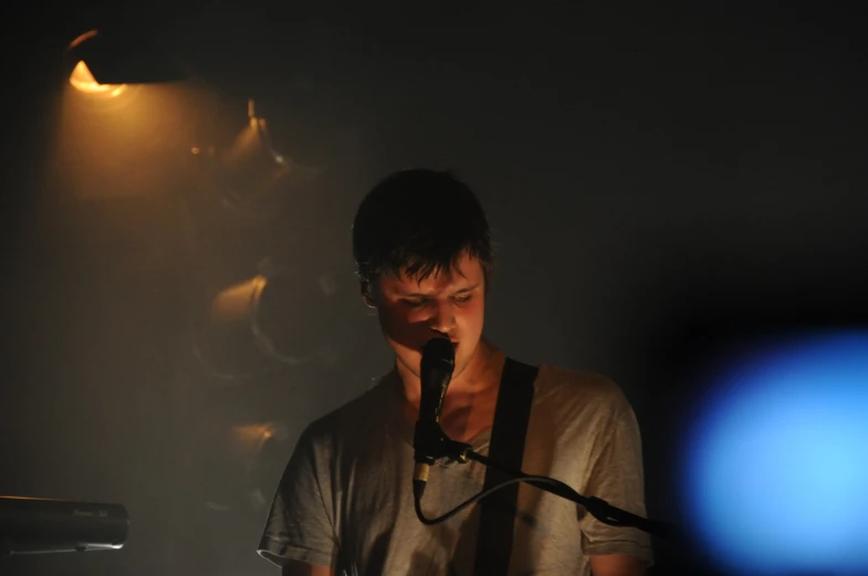 a man standing next to a microphone with a light on