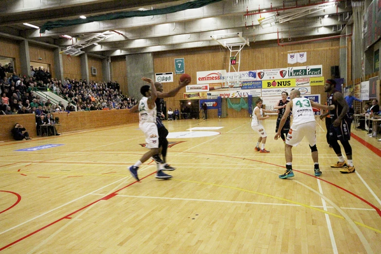 several people playing basketball on a gym court