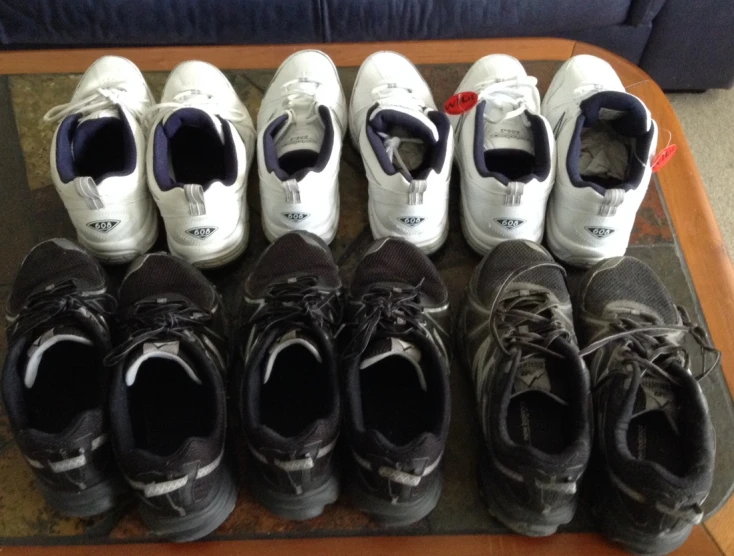 a table filled with pairs of black and white shoes