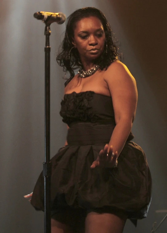 a woman is standing in front of a microphone