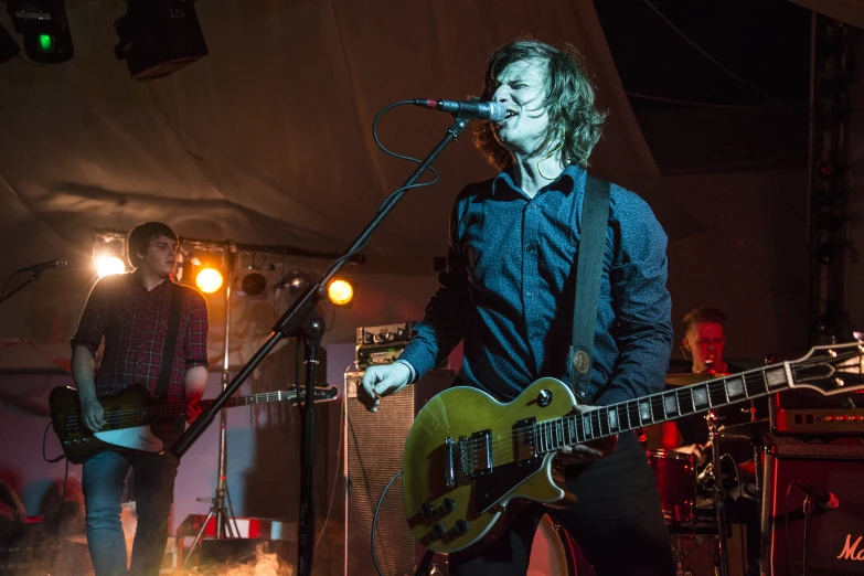 a person standing on a stage playing the guitar