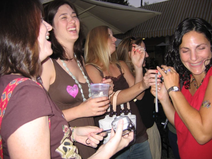 a group of women in red shirts are having drinks