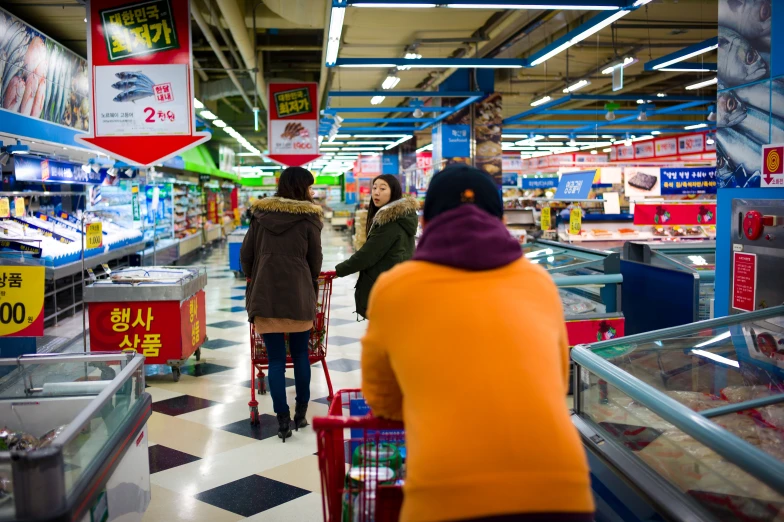 the people walk along the aisle of an aisle of shops