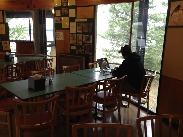 a man is at a dining room table looking out the window